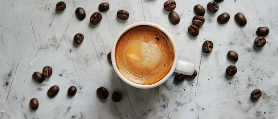 Zelfklevend Fotobehang A cup of espresso with crema on top, surrounded by coffee beans on a textured background © Seksan