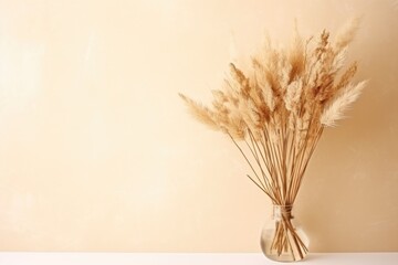 Bouquet of dry wheat and grasses in a vase with warm light and shadows.