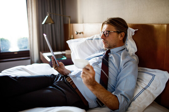 Mature businessman using a tablet while in a hotel room - Powered by Adobe