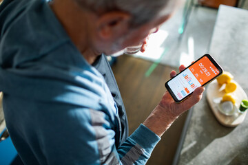 Elderly man checking health app on smartphone for fitness tracking