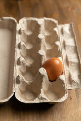 Egg in a cardboard biodegradable box on a wooden table.