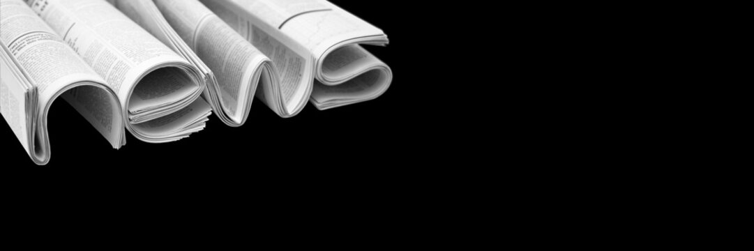 Modern newspapers are folded and composing together the word NEWS, isolated over background. Concept of business news, news media, print media and mass media at all. Copy space for your text