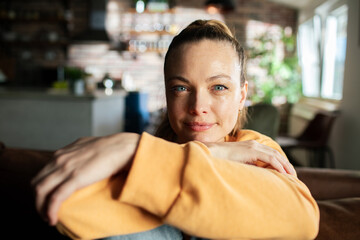 Portrait of a smiling woman relaxing on couch at home
