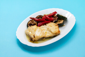 Fish dish - fried cod fish with grilled vegetables in plate