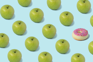 Pattern pink donuts and green apples isolated on blue background. Sweet junk food vs healthy food concept.