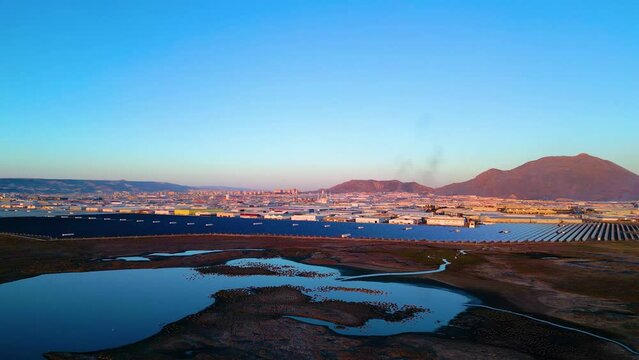 Evening aerial view of factories and a giant solar energy field