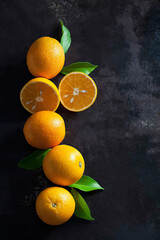 fresh oranges in a row on black background