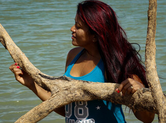 Woman with beautiful red hair, walking among the dry trees of the Três Marias dam on the São Francisco River, in a very dry season, with very low water.