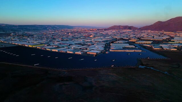 Evening aerial view of factories and a giant solar energy field