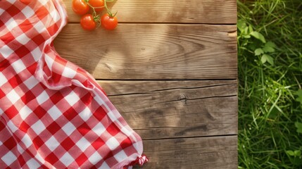 Sunlit Vintage Red Checkered Picnic Tablecloth on Wooden Table with Tomatoes and Grass Texture Background with Copy Space. Top View, From Above