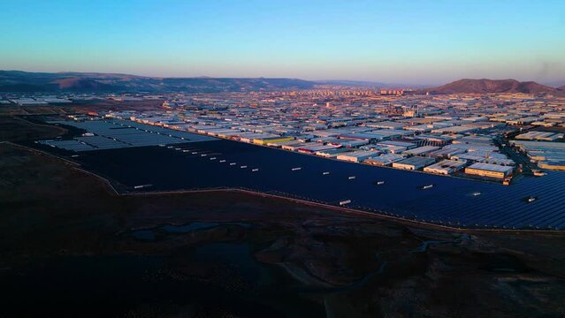 Evening aerial view of factories and a giant solar energy field