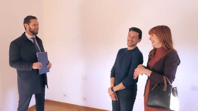 young couple with the real estate agent in the apartment they intend to buy