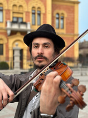 homeless man playing the violin, street musician 