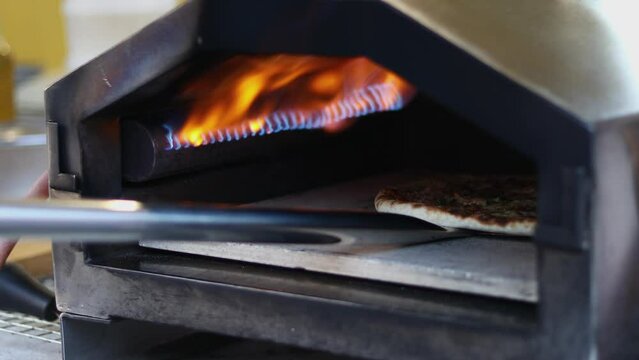 Pizza is baked in the oven near the burning.