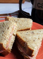 Closeup of a cold meat sandwich on multigrain bread with coffee.