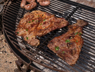 Top view of crispy meat and pork sausages roasting in the metal grill