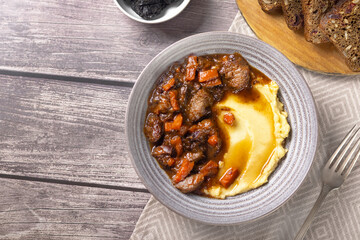 Meat with prunes, goulash and mashed potatoes vertical tasty food photo