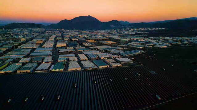 Evening aerial view of factories and a giant solar energy field