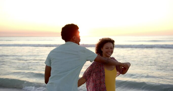 Biracial couple enjoys a serene beach sunset with copy space, their faces close together