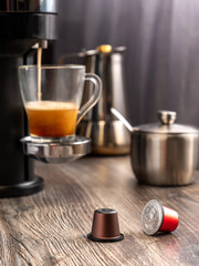 Capsules for making coffee in a coffee machine lie on the table against the background of a coffee machine.