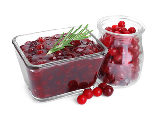 Tasty cranberry sauce in bowl and glass jar with fresh berries isolated on white