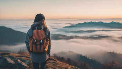 Fototapete Rund Hipster young girl with backpack enjoying sunset on peak of foggy mountain. © Adi