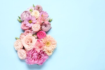 8 March greeting card design made with beautiful flowers on light blue background, top view. Space for text