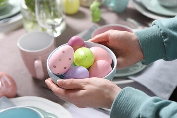 Woman setting table for festive Easter dinner at home, closeup