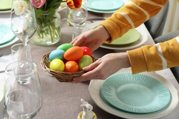 Woman setting table for festive Easter dinner at home, closeup
