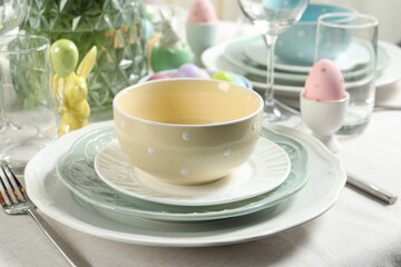 Easter celebration. Festive table setting with elegant dishware and painted eggs