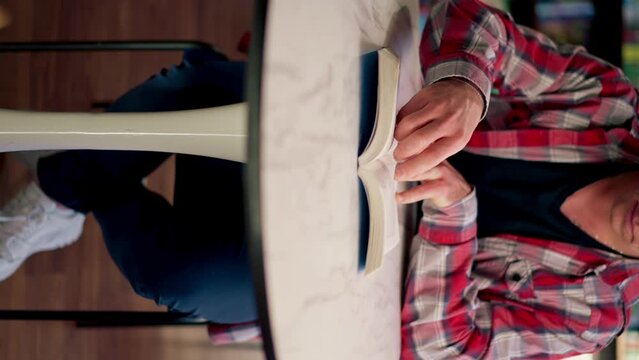 vertical video close-up male sits in scientific and technical library reads a book and prepares write a dissertation