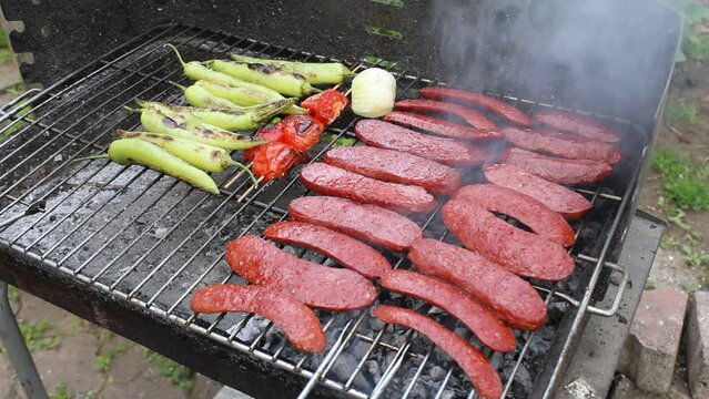 delicious grilled sausage cooked on the barbecue. tomatoes and peppers.