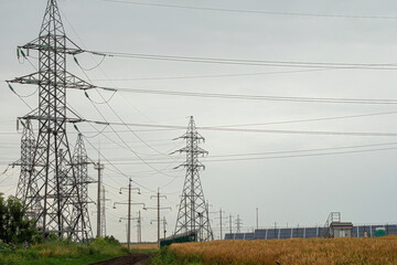 Power lines transmitting clean energy from alternative form against grey sky. Generation of...