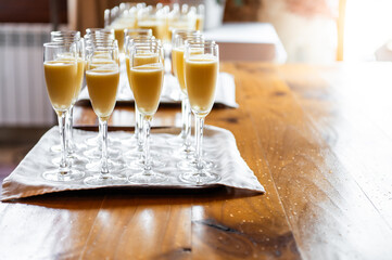 Tray full of glasses of lemon or mango sorbet with cava, ready to be served at an event by the...