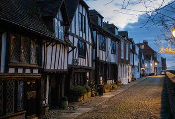 Old town cobbled street and historic houses in Rye during a sunset on a cloudy day