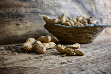 walnuts in ceramic bowl and wooden background, side view of blurred bowl full of walnuts