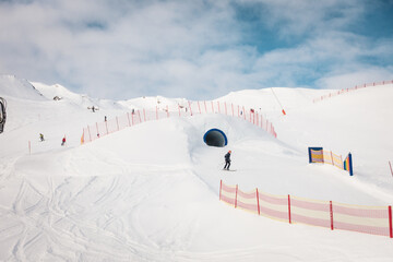 Ski resort in winter Alps. Skiers ride down the slope. Tux, Hintertux, Austria.