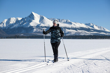 young woman cross country skiing on a snowy meadow with a view of the High Tatras-Kriv&aacute;ň