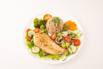Grilled chicken in a plate with salad and rice sprinkled with sesame seeds front view
