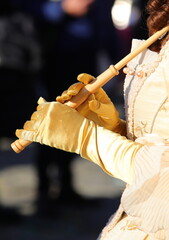 hands of a young woman dressed in historical dress holding the handle of an umbrella with yellow...