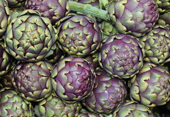 Fototapeta premium Background of large ripe green artichokes for sale