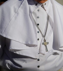 priest with white cassock and silver cross during religious service in the Vatican city