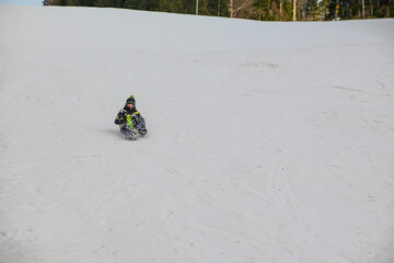 children are sledding on a big hill