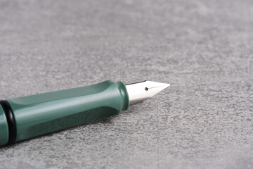 Fountain pen is green on a gray background.