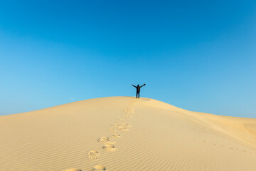 A male Photographer step by step walking on Desert Landscape in Abqaiq Dammam Saudi Arabia.