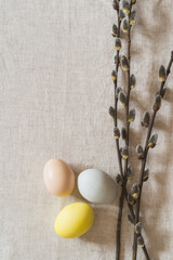 Overhead shot of colourful Easter eggs and twigs on linen tablecloth - 748940380