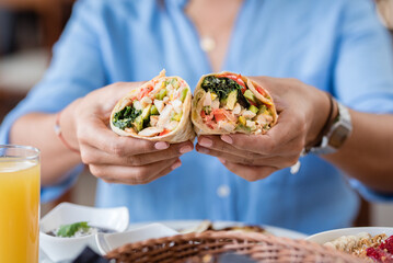 person eating chicken wrap