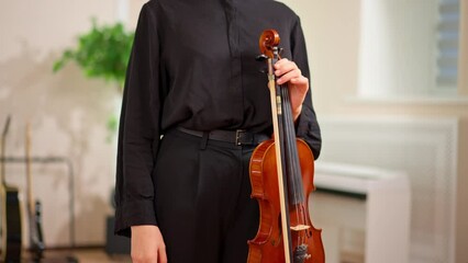 a young teacher of musical skills in the rehearsal hall with a violin in her hands creativity hobby