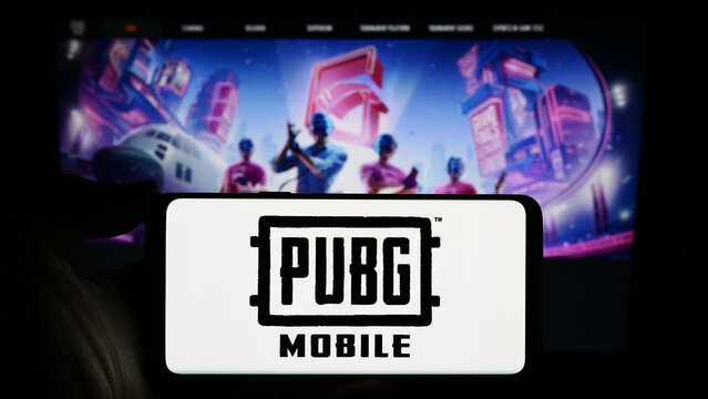 Stuttgart, Germany - 02-22-2024: Person holding cellphone with logo of battle royale video game PUBG Mobile in front of company webpage. Focus on phone display.