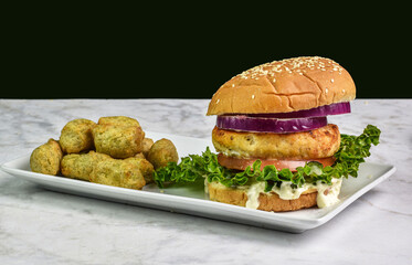 salmon burger on sesame bun with veggie tots,